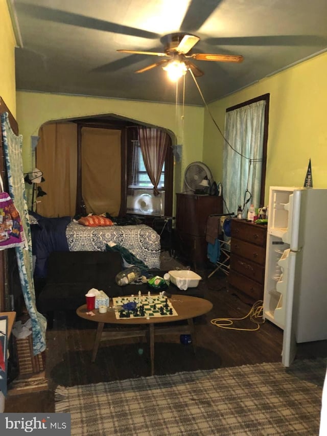 bedroom featuring ceiling fan, white refrigerator, and dark hardwood / wood-style floors