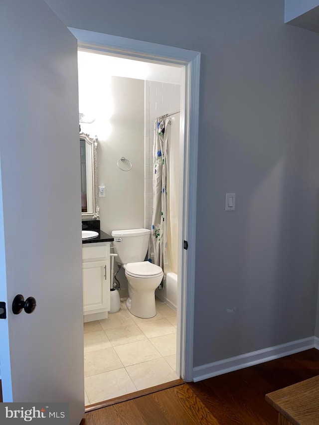 full bathroom featuring vanity, wood-type flooring, shower / bath combination with curtain, and toilet