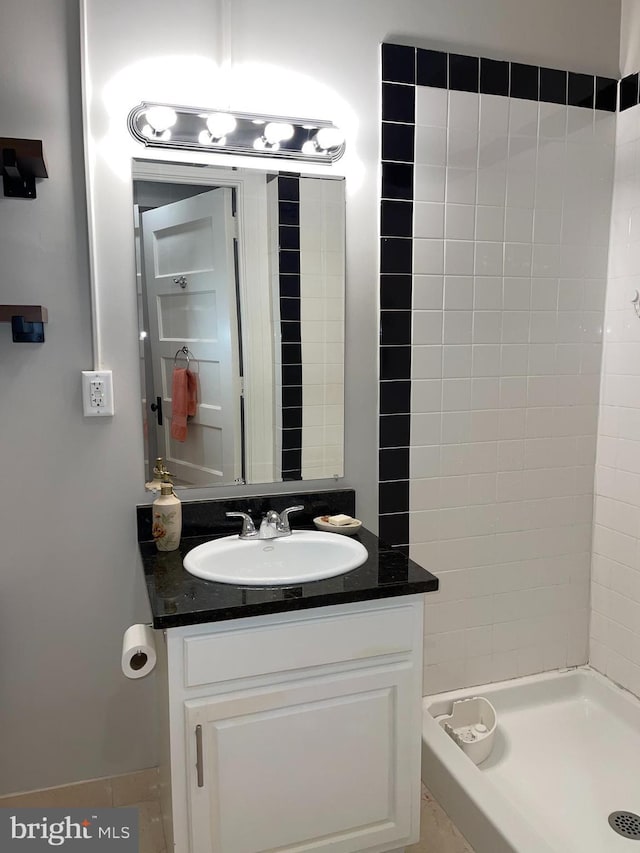 bathroom featuring walk in shower and vanity