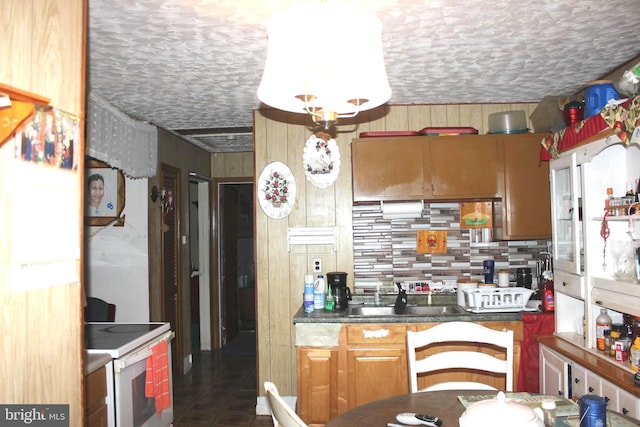 kitchen with tasteful backsplash, white range with electric cooktop, sink, and a textured ceiling