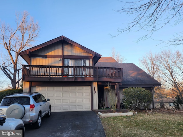 view of front of home with a garage, driveway, and a shingled roof