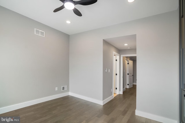 spare room featuring dark wood-type flooring and ceiling fan