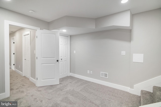 basement featuring light carpet