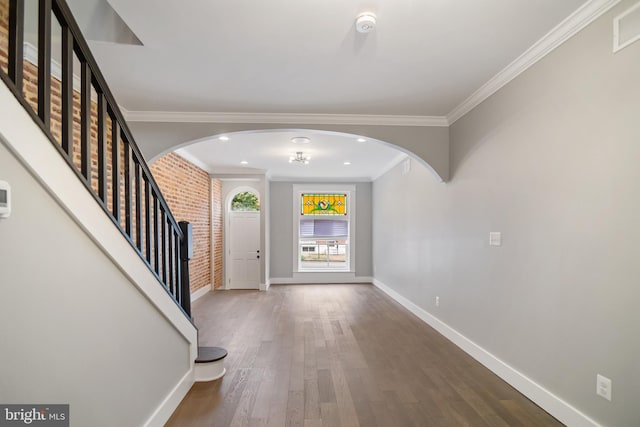 foyer featuring wood-type flooring and crown molding