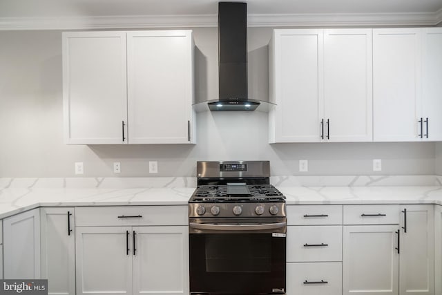 kitchen with wall chimney exhaust hood, white cabinets, light stone counters, and stainless steel gas range oven