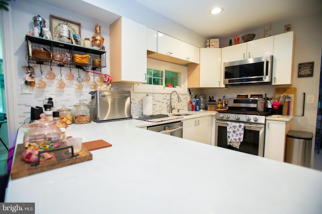 kitchen featuring white cabinetry, sink, decorative backsplash, and stainless steel appliances