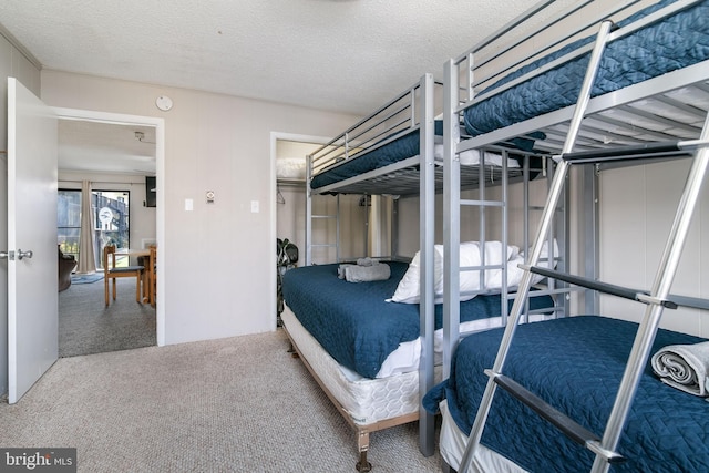 bedroom featuring a textured ceiling and carpet flooring