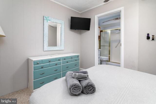 bedroom with a textured ceiling, ornamental molding, and connected bathroom