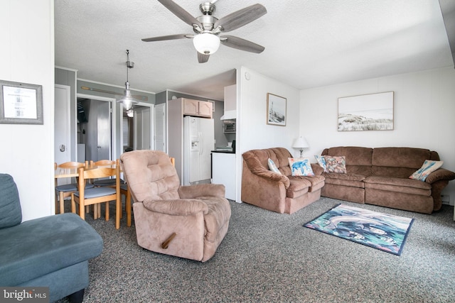 living area with ceiling fan, dark colored carpet, and a textured ceiling