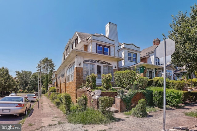 townhome / multi-family property with brick siding and a chimney