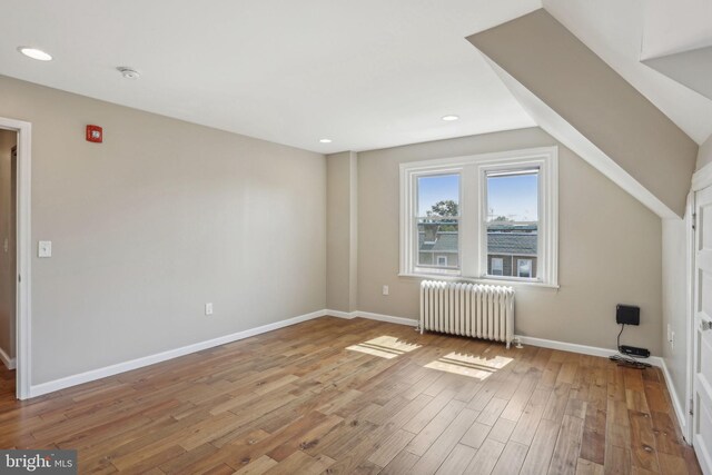 bonus room featuring radiator and hardwood / wood-style flooring