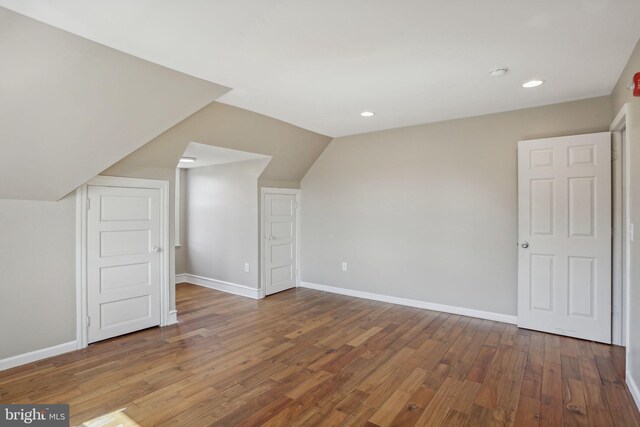 additional living space featuring lofted ceiling and hardwood / wood-style flooring