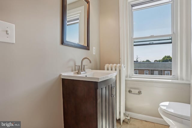 bathroom with tile patterned floors, vanity, toilet, and a healthy amount of sunlight