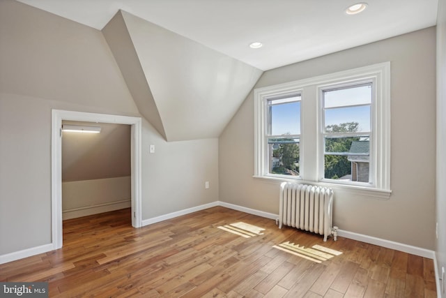 bonus room with lofted ceiling, radiator, and hardwood / wood-style flooring