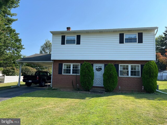 view of front of home with a front lawn and a carport