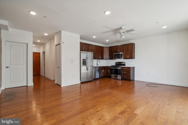 kitchen featuring ceiling fan, appliances with stainless steel finishes, and light hardwood / wood-style floors