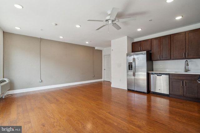 kitchen featuring ceiling fan, appliances with stainless steel finishes, light hardwood / wood-style floors, and sink