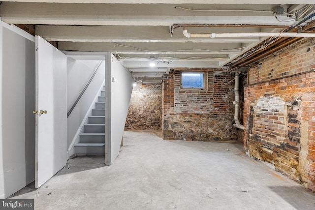 basement featuring brick wall