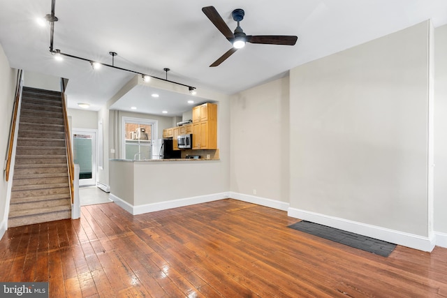 unfurnished living room with hardwood / wood-style flooring, rail lighting, and ceiling fan