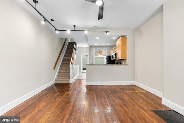 unfurnished living room with track lighting, dark hardwood / wood-style flooring, and ceiling fan