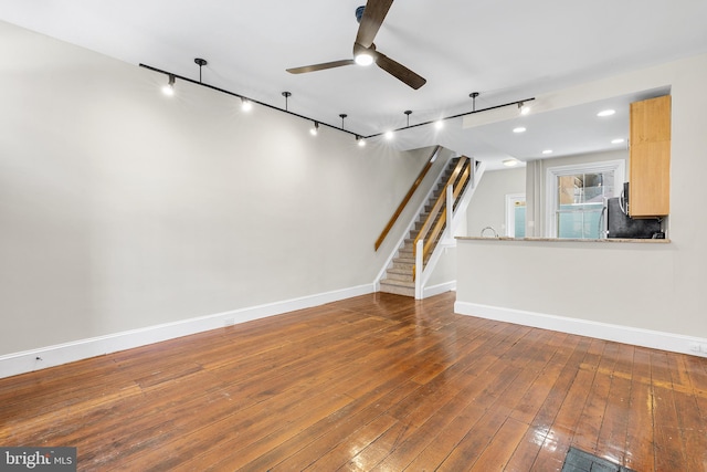 unfurnished living room with ceiling fan, hardwood / wood-style flooring, and track lighting