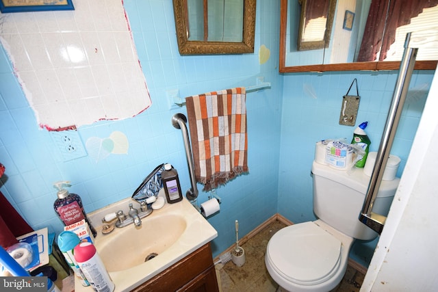 bathroom featuring vanity, tile walls, and toilet