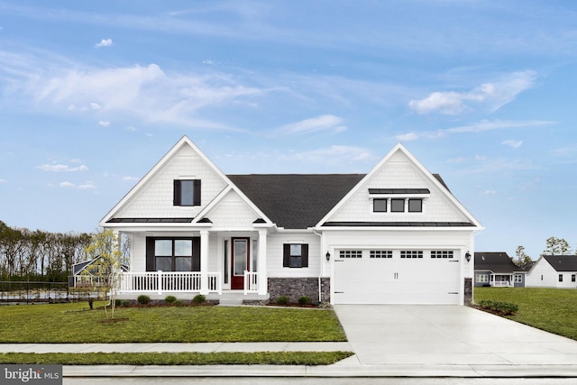 view of front of property featuring a garage, a front yard, and covered porch