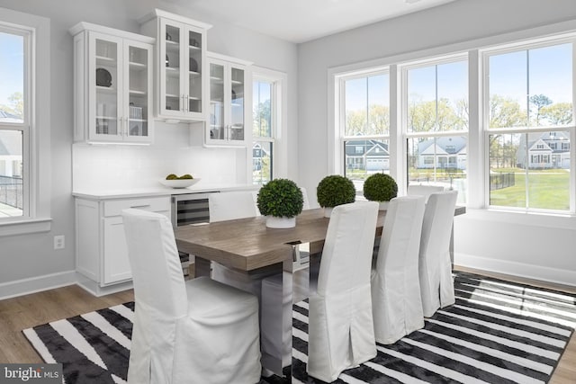 dining space featuring light wood-type flooring and beverage cooler