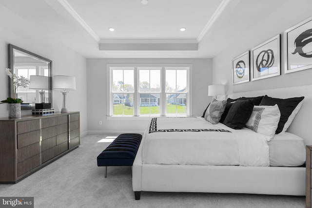 bedroom featuring light colored carpet, a tray ceiling, and ornamental molding