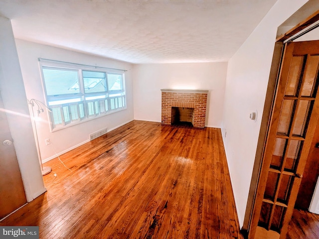 unfurnished living room with hardwood / wood-style flooring and a fireplace