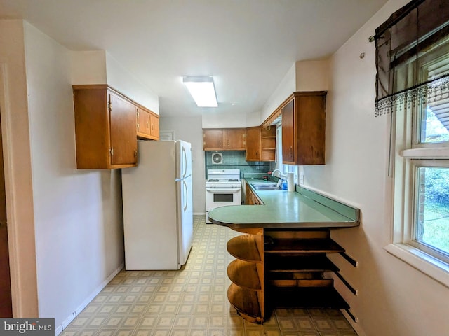 kitchen featuring tasteful backsplash, light tile patterned floors, sink, kitchen peninsula, and white appliances