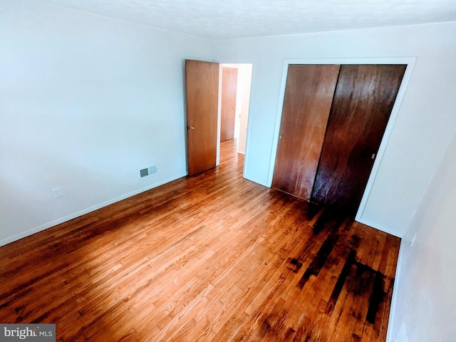 unfurnished bedroom with hardwood / wood-style flooring and a closet