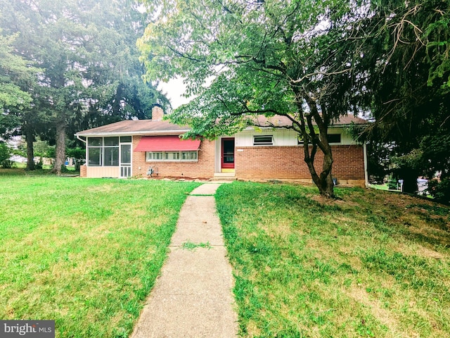 single story home with a sunroom and a front lawn