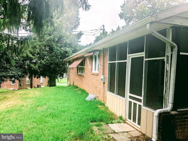 view of property exterior featuring a yard and a sunroom