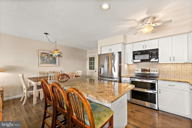 kitchen featuring a kitchen island, appliances with stainless steel finishes, dark wood-type flooring, and white cabinets