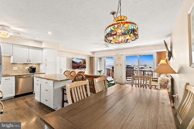 dining area with dark hardwood / wood-style floors, ceiling fan, and a textured ceiling