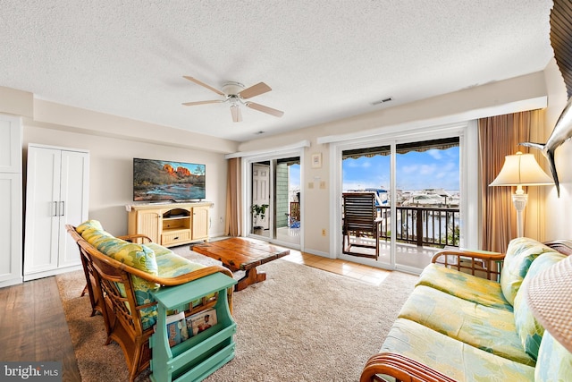 living room featuring a textured ceiling and ceiling fan