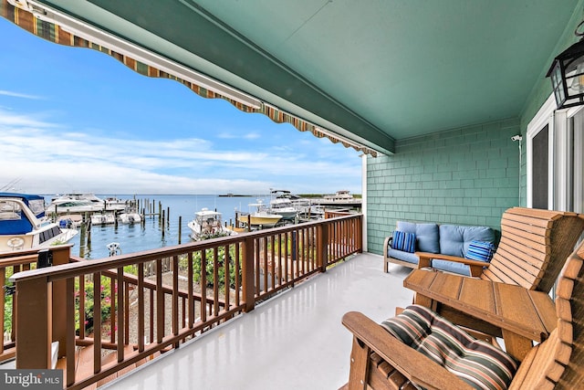 balcony featuring a boat dock, a water view, and an outdoor hangout area