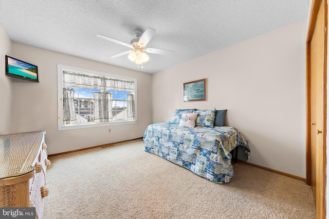 carpeted bedroom with a textured ceiling, a closet, and ceiling fan