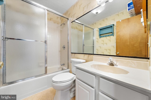 full bathroom featuring vanity, tile patterned floors, shower / bath combination with glass door, toilet, and a textured ceiling