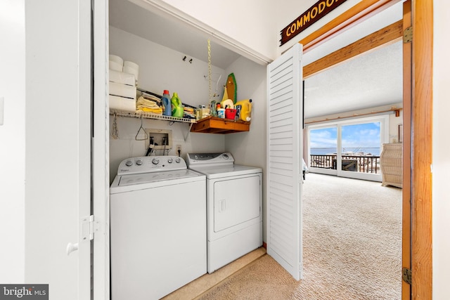 clothes washing area featuring separate washer and dryer and light carpet