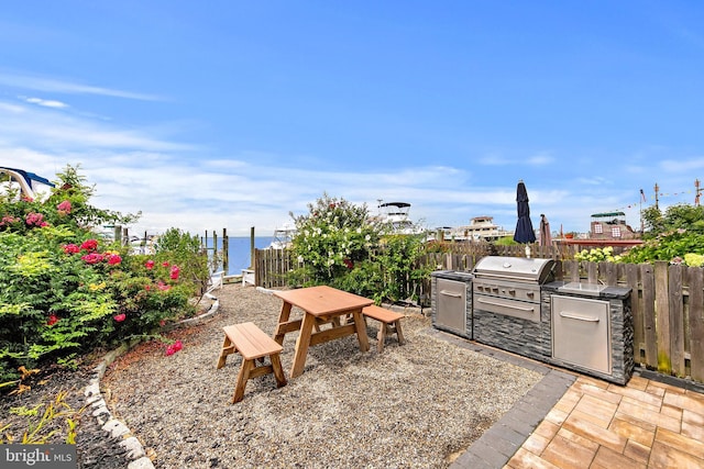 view of yard with a water view, exterior kitchen, and a patio area