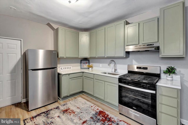 kitchen featuring green cabinets, stainless steel appliances, light hardwood / wood-style floors, and sink