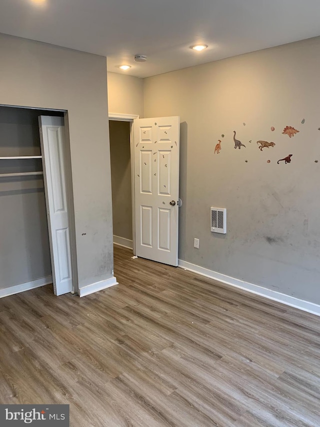 unfurnished bedroom with hardwood / wood-style floors and a closet