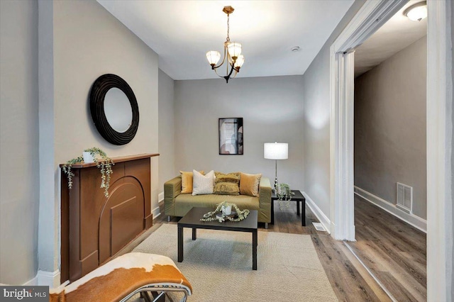 sitting room featuring wood-type flooring and a notable chandelier