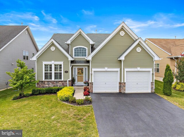 view of front of home with a front lawn, central AC unit, and a garage