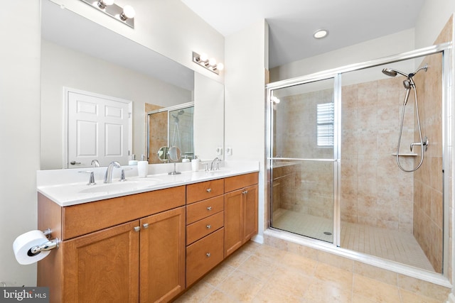 bathroom featuring a shower with shower door, tile patterned floors, and vanity