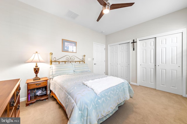 bedroom with multiple closets, light colored carpet, and ceiling fan