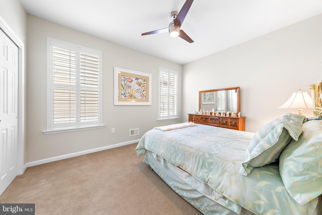 carpeted bedroom with ceiling fan and a closet