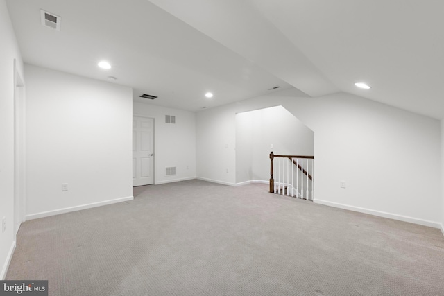 additional living space with light carpet and vaulted ceiling